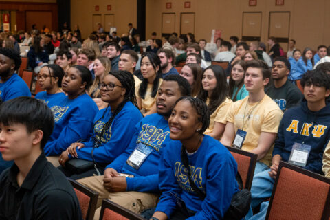 Students sitting in chairs in rows looking towards the left at the speaker.